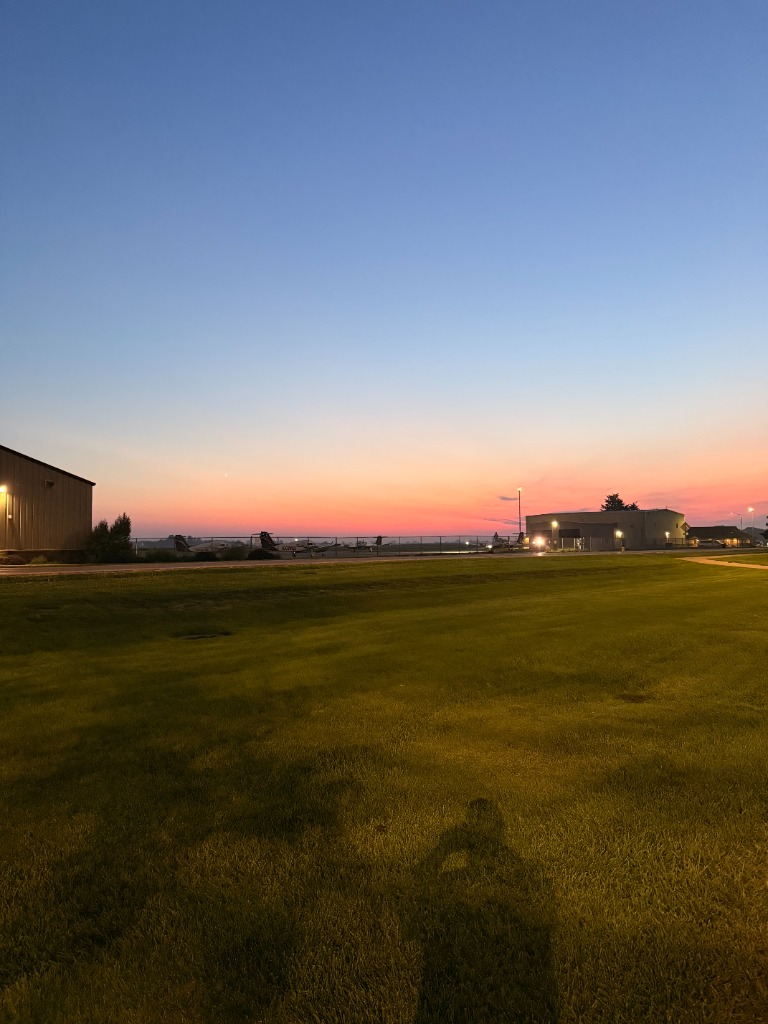 Airfield hangars and runway grass during twilight dusk